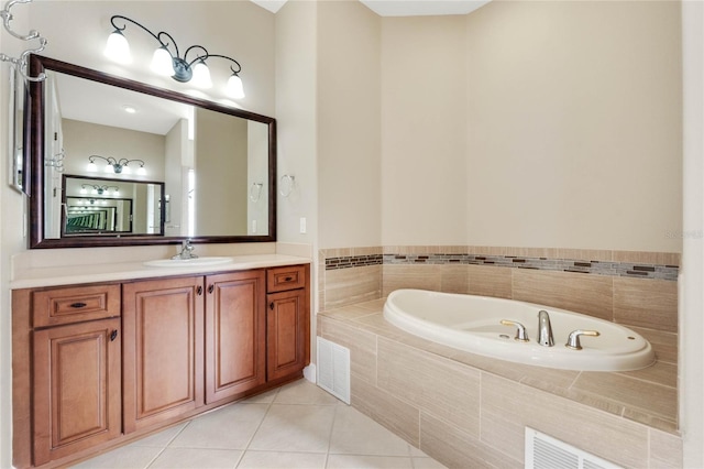 bathroom featuring tile patterned flooring, vanity, and tiled tub