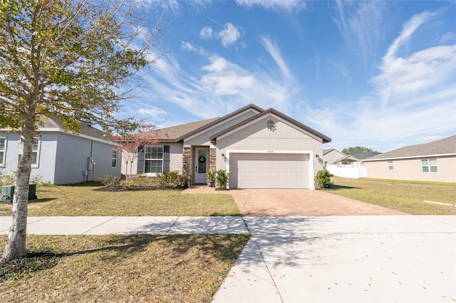 single story home featuring a garage and a front lawn