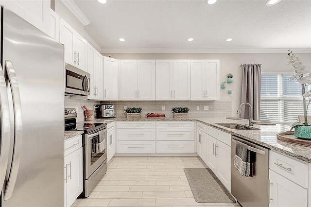 kitchen with white cabinetry, sink, light stone counters, and appliances with stainless steel finishes