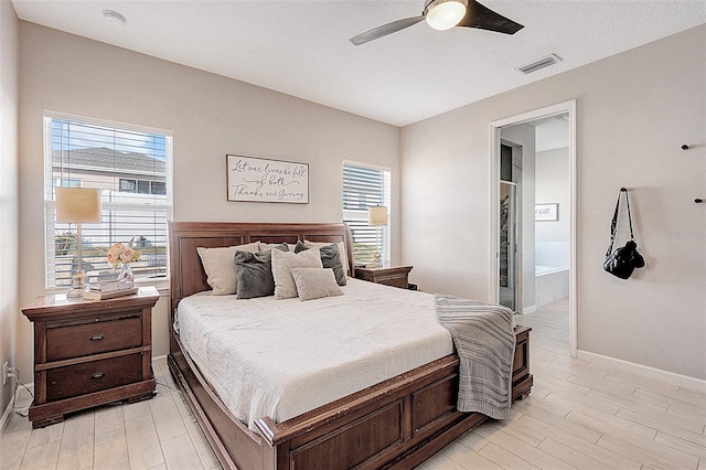 bedroom with ceiling fan, connected bathroom, and light hardwood / wood-style flooring