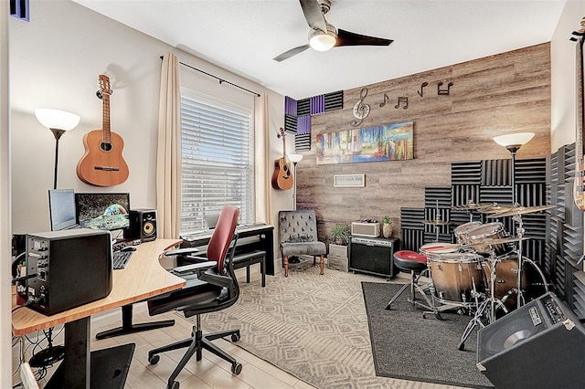 office space with tile patterned floors, ceiling fan, and wood walls