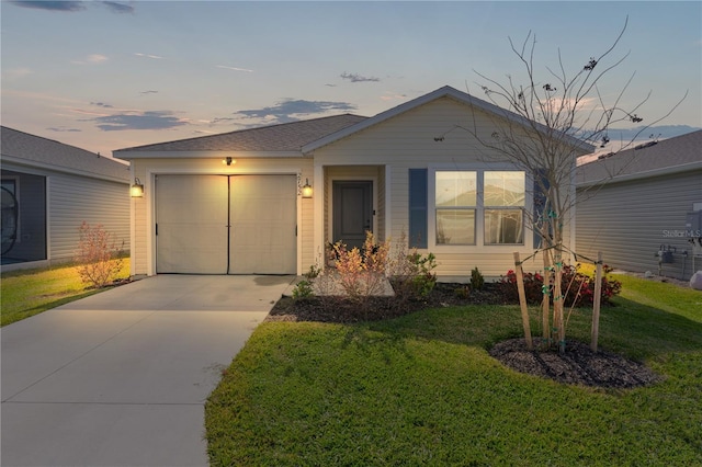 view of front of property with a garage and a yard