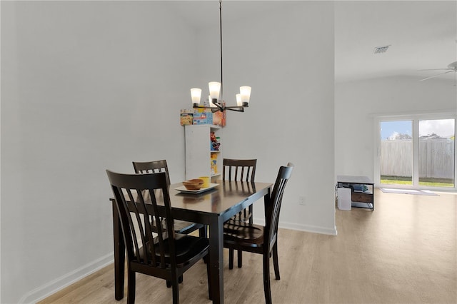 dining space with light hardwood / wood-style floors and ceiling fan with notable chandelier