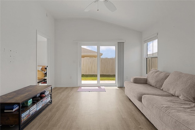 living room featuring vaulted ceiling, ceiling fan, and light hardwood / wood-style flooring