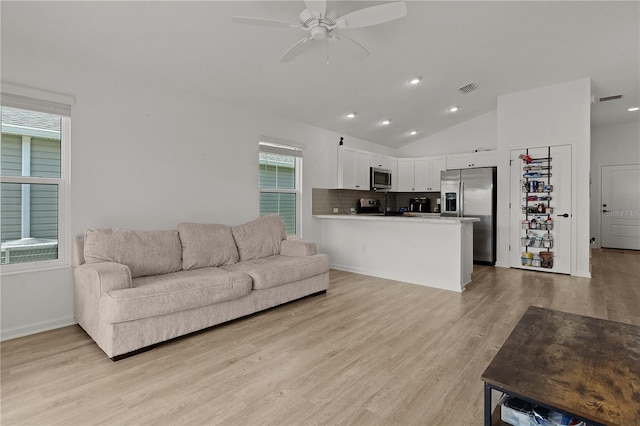 living room with light hardwood / wood-style floors, lofted ceiling, and ceiling fan