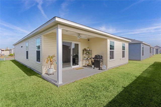 back of property with ceiling fan, a patio, and a lawn