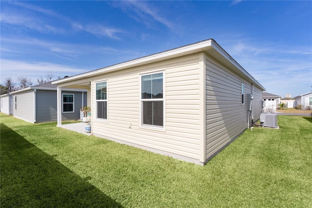 rear view of house featuring central AC, a lawn, and a patio area