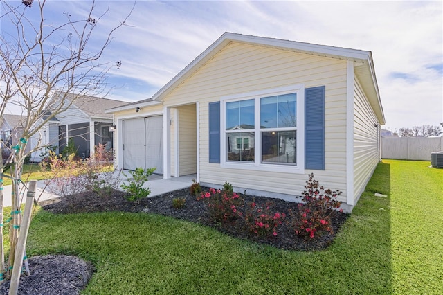 view of front of property with a front lawn, a garage, and cooling unit