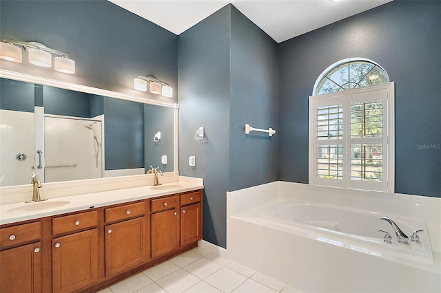 bathroom with vanity, tile patterned flooring, and tiled tub