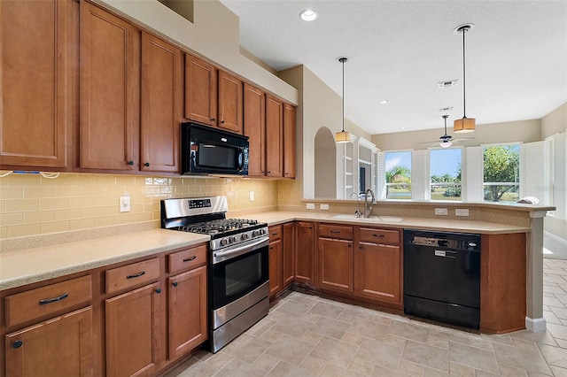 kitchen with decorative light fixtures, black appliances, sink, decorative backsplash, and kitchen peninsula