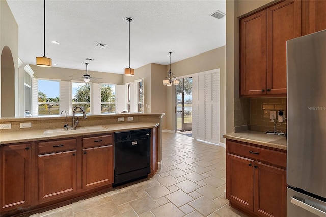 kitchen featuring pendant lighting, sink, stainless steel fridge, black dishwasher, and tasteful backsplash