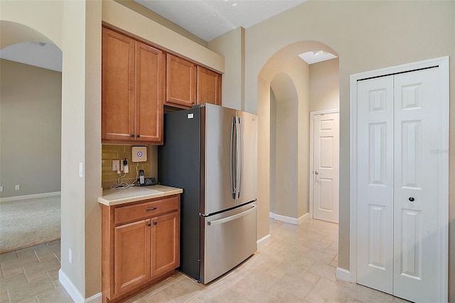 kitchen with backsplash and stainless steel refrigerator