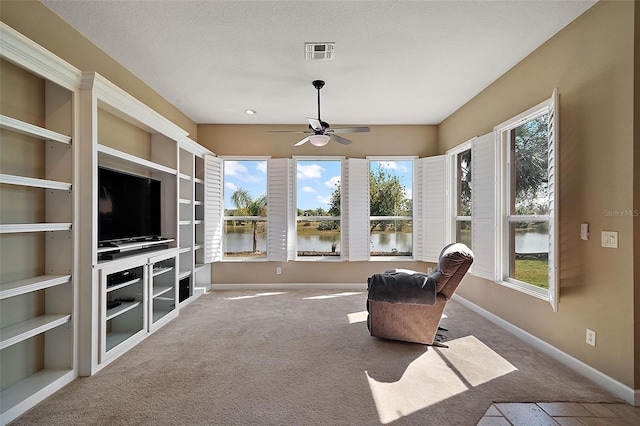 sunroom with a water view, a wealth of natural light, and ceiling fan