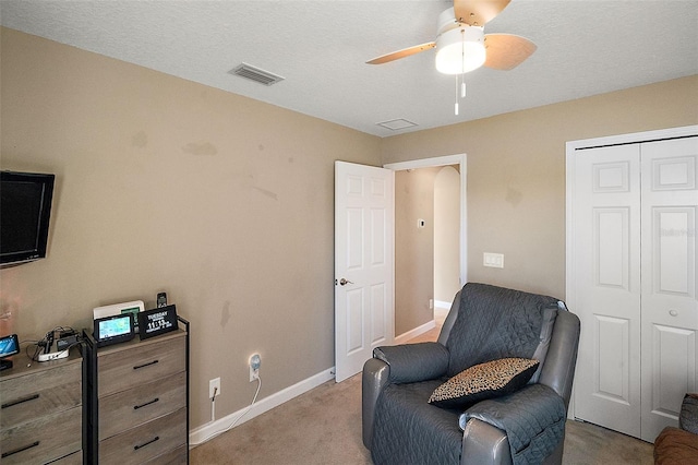 living area with light carpet and ceiling fan