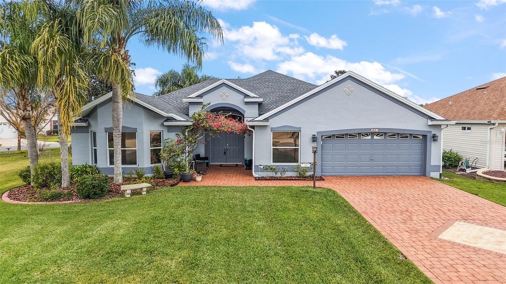 single story home featuring a garage and a front lawn