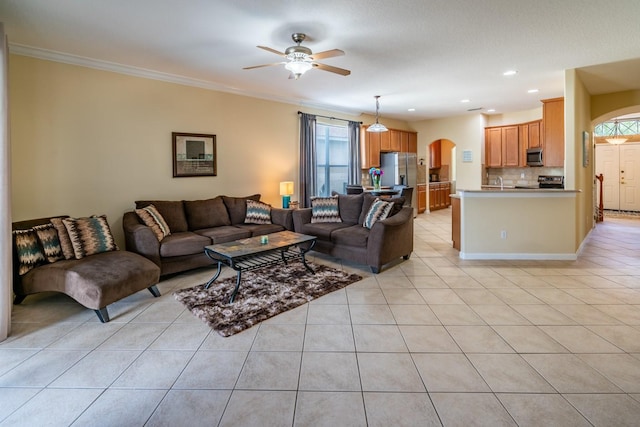 tiled living room with sink, a wealth of natural light, ornamental molding, and ceiling fan