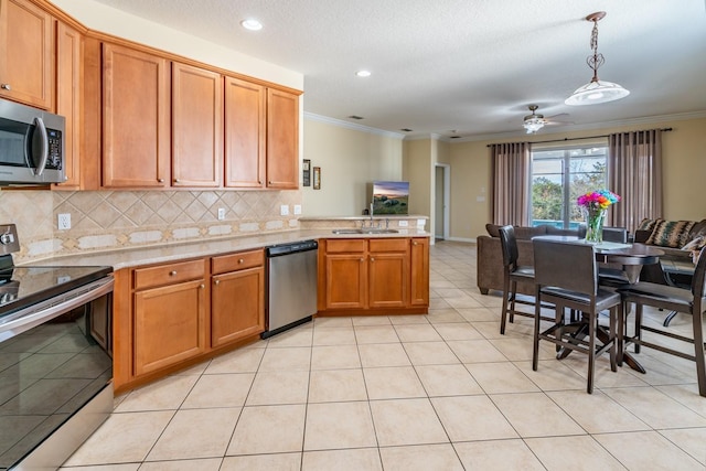 kitchen with sink, tasteful backsplash, crown molding, hanging light fixtures, and stainless steel appliances