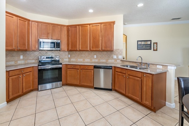 kitchen with appliances with stainless steel finishes, tasteful backsplash, sink, light tile patterned floors, and kitchen peninsula