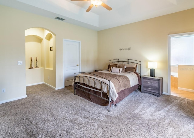 bedroom featuring light carpet, a raised ceiling, and ceiling fan