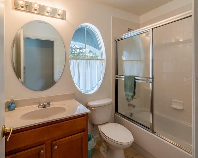 full bathroom with bath / shower combo with glass door, vanity, and toilet