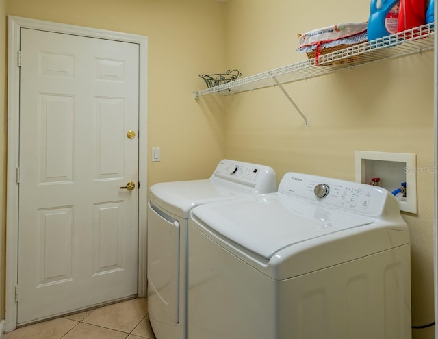 laundry area with light tile patterned floors and washer and clothes dryer