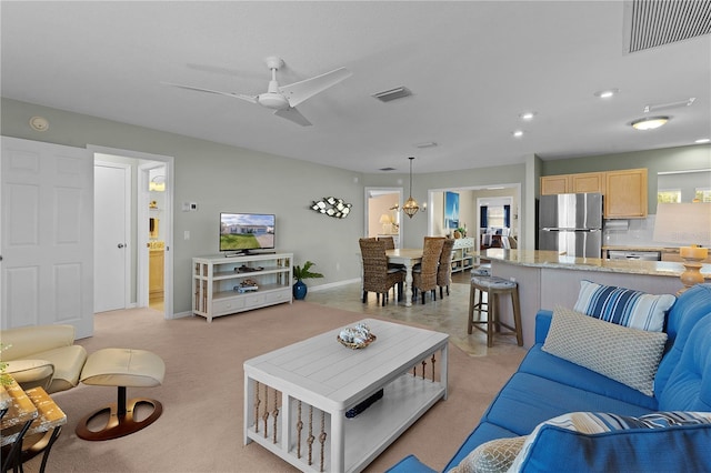 living room featuring light carpet and ceiling fan