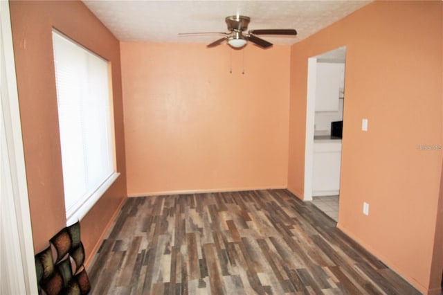 spare room with dark wood-type flooring, ceiling fan, and a textured ceiling