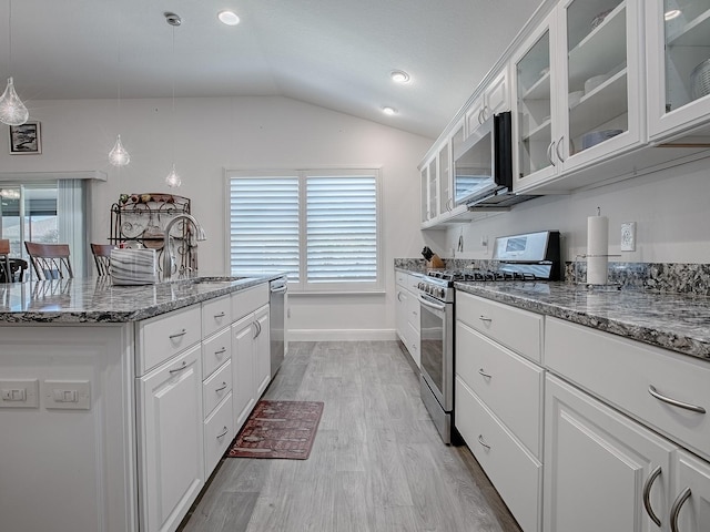 kitchen with sink, hanging light fixtures, dark stone countertops, stainless steel appliances, and white cabinets