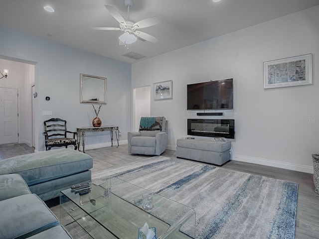 living room featuring hardwood / wood-style floors and ceiling fan with notable chandelier