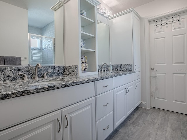 bathroom featuring hardwood / wood-style flooring, vanity, and an enclosed shower