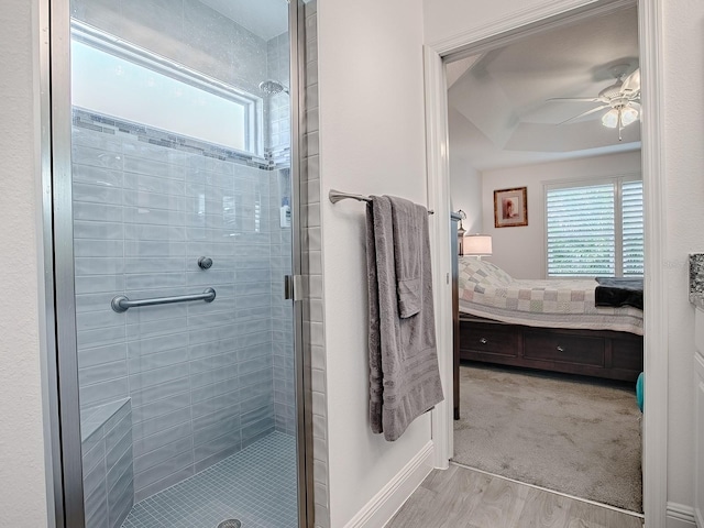 bathroom with ceiling fan, a healthy amount of sunlight, and an enclosed shower