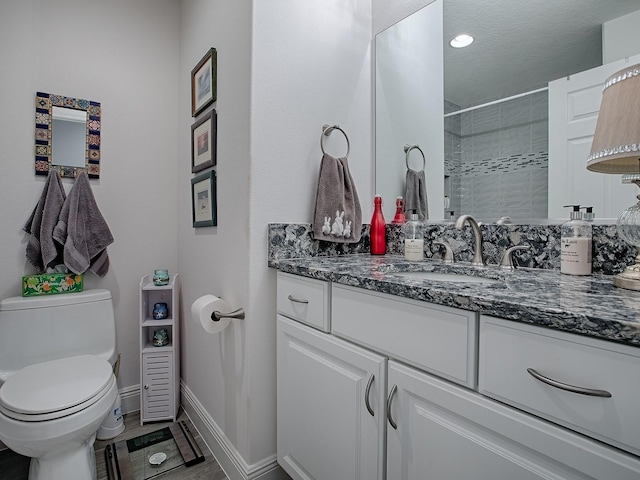 bathroom featuring vanity, toilet, hardwood / wood-style floors, and a tile shower