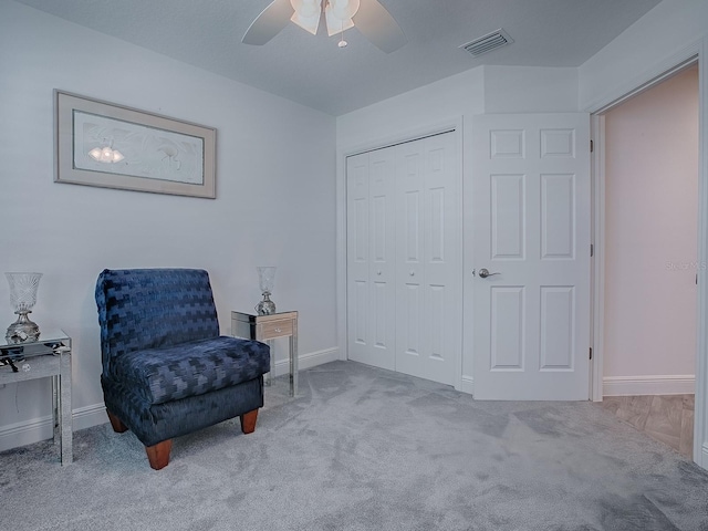 living area with ceiling fan and light colored carpet