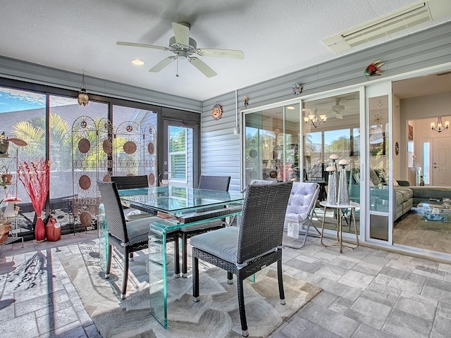 sunroom with ceiling fan with notable chandelier