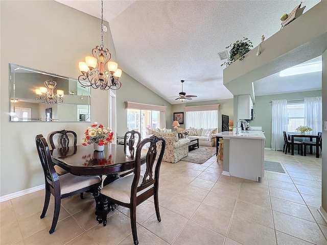 tiled dining room featuring lofted ceiling, plenty of natural light, sink, and a textured ceiling