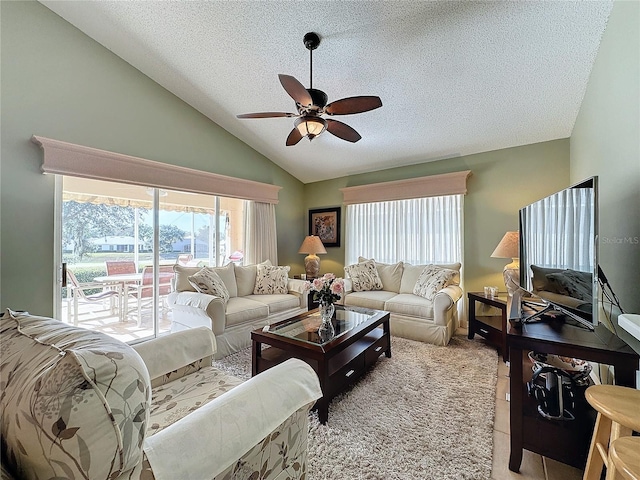 living room featuring ceiling fan, lofted ceiling, and a textured ceiling