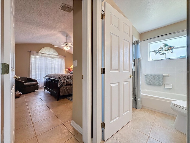 interior space featuring tile patterned floors, plenty of natural light, toilet, and shower / tub combo