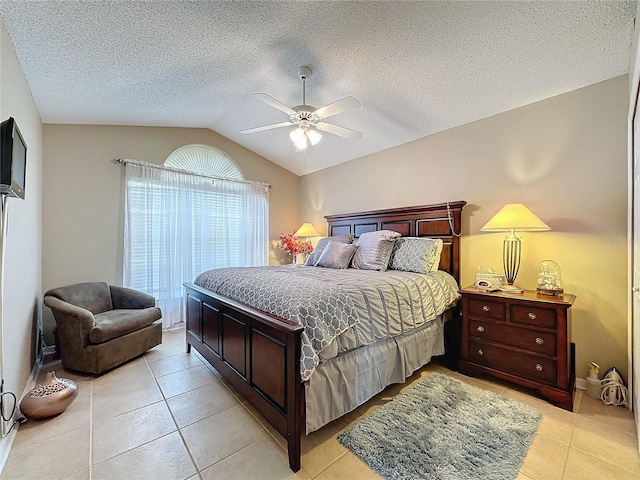 bedroom featuring a textured ceiling, vaulted ceiling, ceiling fan, and light tile patterned flooring