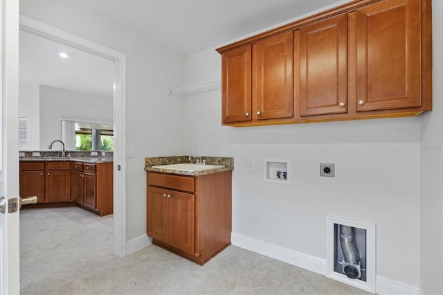 clothes washing area featuring cabinets, electric dryer hookup, sink, and washer hookup