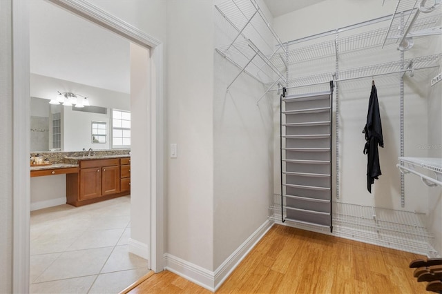 walk in closet with sink and light tile patterned floors