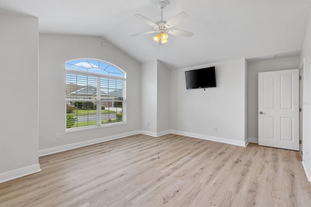 empty room with ceiling fan, vaulted ceiling, and light wood-type flooring