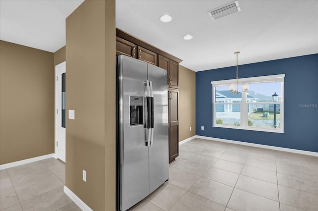 kitchen featuring light tile patterned floors, hanging light fixtures, dark brown cabinets, stainless steel fridge with ice dispenser, and a chandelier