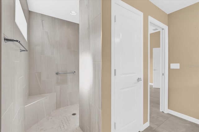 bathroom featuring tile patterned floors and a tile shower