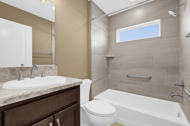 full bathroom with vanity, tiled shower / bath, and toilet