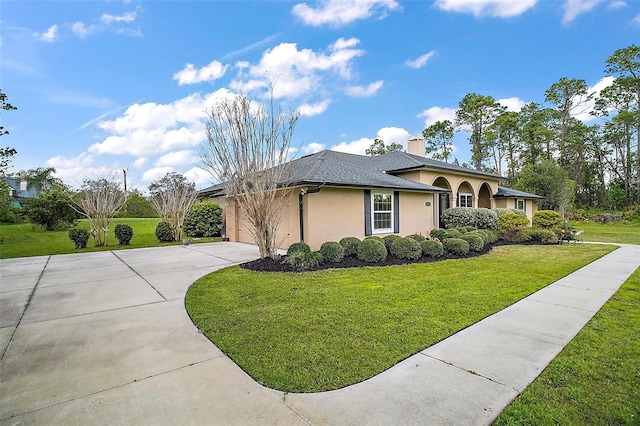 view of side of home with concrete driveway, a yard, an attached garage, and stucco siding