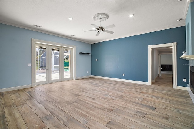 empty room featuring ornamental molding, french doors, visible vents, and light wood-style flooring