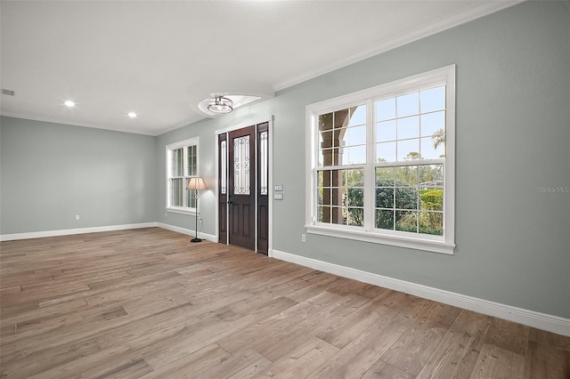 foyer featuring crown molding, baseboards, and wood finished floors