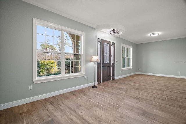 entryway featuring baseboards, wood finished floors, and ornamental molding