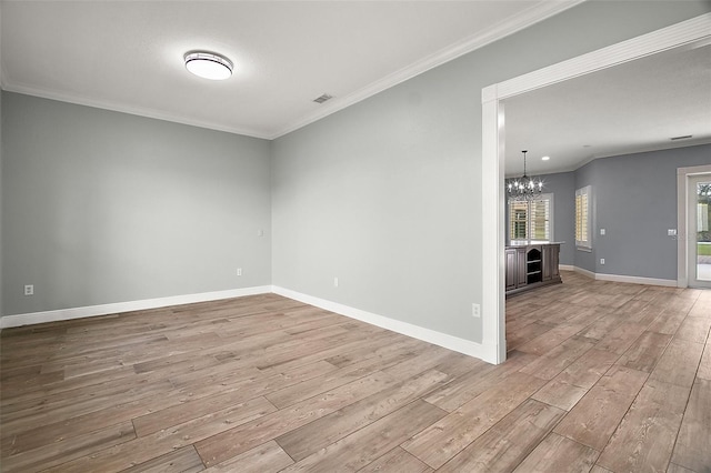 unfurnished room featuring light wood finished floors, baseboards, and ornamental molding