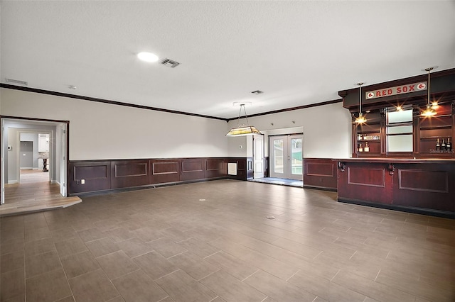 interior space featuring french doors, visible vents, and crown molding